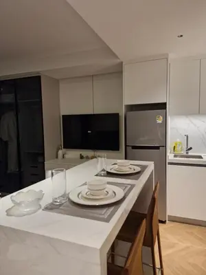 a kitchen with a table with plates and glasses on it at Kora Beach Resort Phuket in Bang Tao Beach