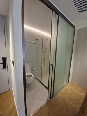 a glass door of a bathroom with a toilet at Kora Beach Resort Phuket in Bang Tao Beach