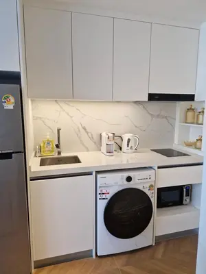 a kitchen with a washing machine and a sink at Kora Beach Resort Phuket in Bang Tao Beach