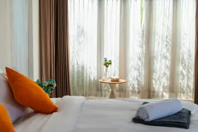a bedroom with a bed with a window and a table at Tropical Pool Villa Thai-modern Villa with an OFFICE in Phuket Town