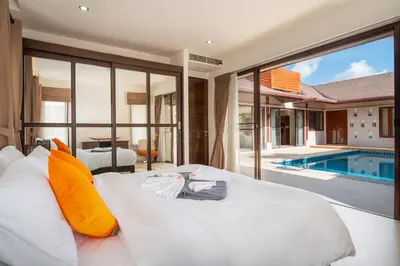 a bedroom with a white bed and a swimming pool at Tropical Pool Villa Thai-modern Villa with an OFFICE in Phuket Town