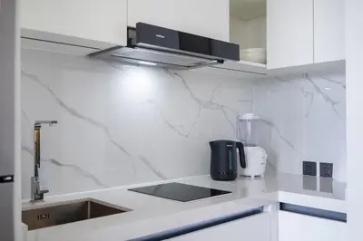 a white kitchen with a counter top with a blender at The Sunshine Beach Resort 1-bedroom with a great view in Layan Beach