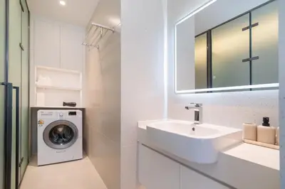 a white bathroom with a washing machine and a sink at The Sunshine Beach Resort 1-bedroom with a great view in Layan Beach