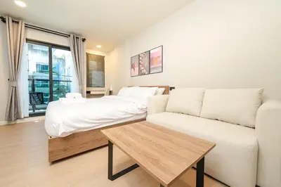 a living room with a couch and a bed at New condo near the sea, Laguna, Choeng Thale 324 in Ban Thalat Choeng Thale