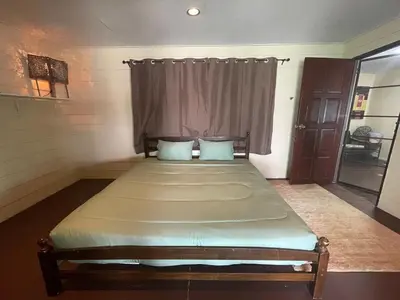 a large bed in a room with a window at Fisherman's house on stilts Phuket Old Town in Ban Tha Khreng