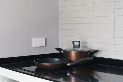 a pair of pots and pans sitting on a stove at The Title Legendary Elegant Suite Bangtao in Ban Thalat Choeng Thale