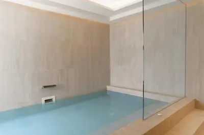 a swimming pool with a glass shower in a room at The Title Legendary Elegant Suite Bangtao in Ban Thalat Choeng Thale