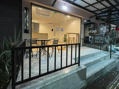 a balcony of a house with a table and chairs at The Nap House Phuket Town in Phuket Town