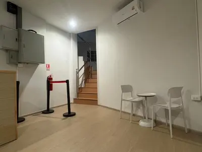 a room with chairs and a table and stairs at The Nap House Phuket Town in Phuket Town