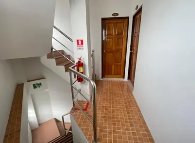 a hallway with a staircase with a door and a fire hydrant at The Nap House Phuket Town in Phuket Town