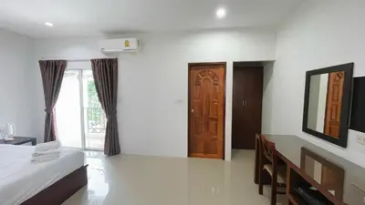 a bedroom with a bed and a wooden door at The Nap House Phuket Town in Phuket Town