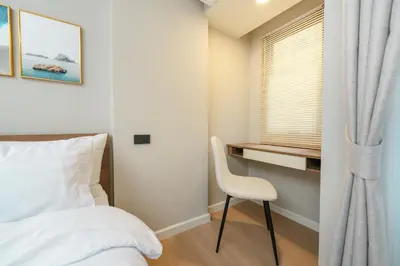 a bedroom with a bed and a desk and a chair at New Condo Boat Avenue Modern Loft 325 in Ban Thalat Choeng Thale