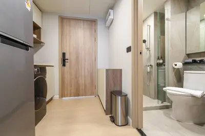 a bathroom with a toilet and a wooden door at New Condo Boat Avenue Modern Loft 325 in Ban Thalat Choeng Thale