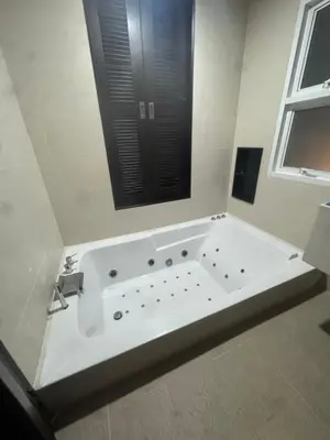 a large white bath tub in a bathroom with a window at Luxury Phuket Pool Villa in Ban Saiyuan (1)