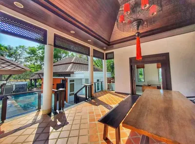 a dining room with a wooden table in a house at Luxury Phuket Pool Villa in Ban Saiyuan (1)