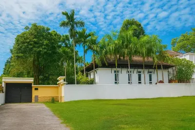 a white house with a garage and palm trees at Luxury Phuket Pool Villa in Ban Saiyuan (1)