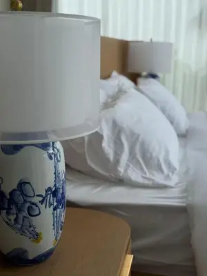 a blue and white lamp on a table next to a bed at Lili House Phuket in Ban Na Nai