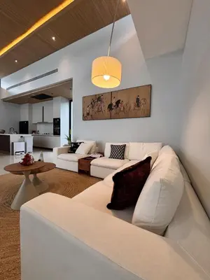 a living room with a white couch and a table at Lili House Phuket in Ban Na Nai