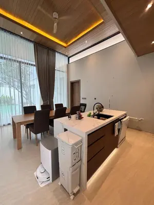 a kitchen with a sink and a table with chairs at Lili House Phuket in Ban Na Nai