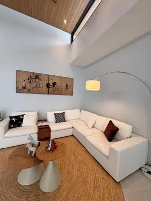 a living room with a white couch and a table at Lili House Phuket in Ban Na Nai