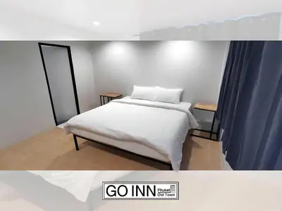 a bedroom with a bed with white sheets at XX GO INN Phuket Old Town โก อินน์ ภูเก็ต ย่านเมืองเก่า in Phuket Town