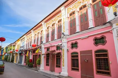 a street in singapore with pink buildings at XX GO INN Phuket Old Town โก อินน์ ภูเก็ต ย่านเมืองเก่า in Phuket Town