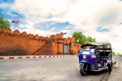 a small vehicle parked in front of a brick wall at XX GO INN Phuket Old Town โก อินน์ ภูเก็ต ย่านเมืองเก่า in Phuket Town