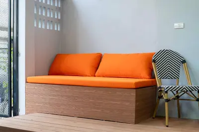 an orange couch in a room with a chair at 3BR pool at Bangla Patong reach beach in 5m walk in Patong Beach
