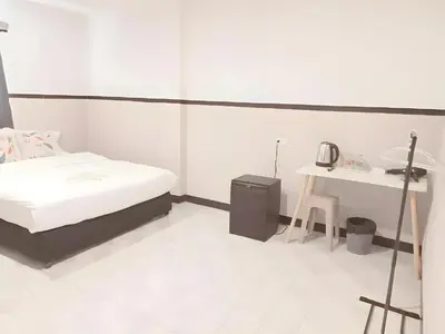 a white room with a bed and a table at XX Mitr Inn - ภูเก็ต เมืองเก่า Phuket Old Town 2 in Phuket Town