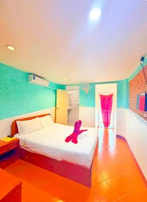 a bedroom with a bed with a pair of shoes on it at Suki Palm in Ban Bang Chak
