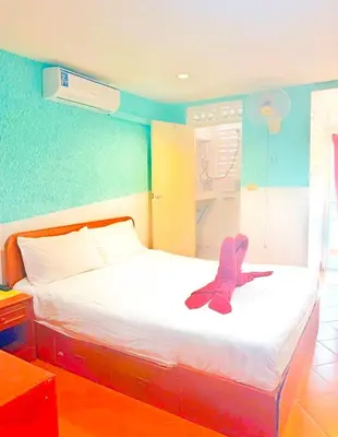 a bed with a pair of shoes sitting on it at Suki Palm in Ban Bang Chak