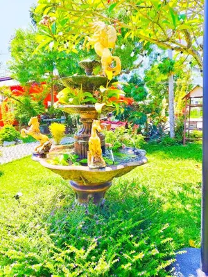 a large bird bath with flowers in a garden at Suki Palm in Ban Bang Chak