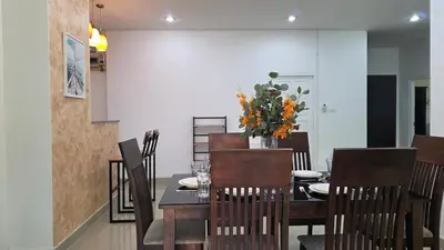a dining room with a table with a vase of flowers at Naiharn Beach Holiday Villa 2, Rawai Phuket in Rawai Beach