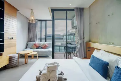 a hotel room with a bed and a living room at 405 Relife 5 Minutes Walk To Nai Harn Beach in Rawai Beach