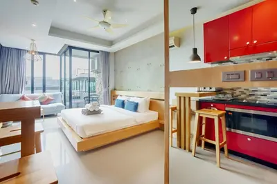 a bedroom with a bed and a kitchen with a table at 405 Relife 5 Minutes Walk To Nai Harn Beach in Rawai Beach