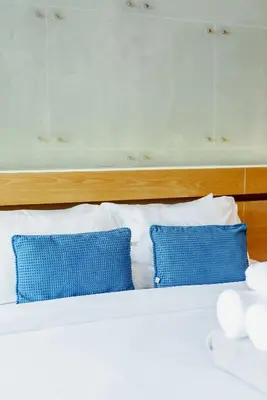 a bed with two blue pillows on top of it at 405 Relife 5 Minutes Walk To Nai Harn Beach in Rawai Beach