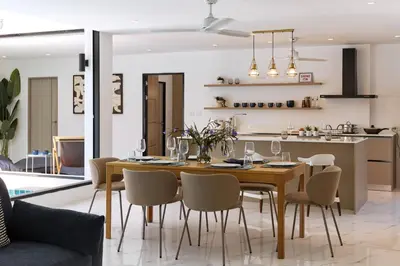 a dining room and kitchen with a table and chairs at Modern Villa 4-BR, Breeze - 10 min walk to NaiYang beach in Nai Yang Beach