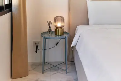 a blue table with a lamp on it next to a bed at Modern Villa 4-BR, Breeze - 10 min walk to NaiYang beach in Nai Yang Beach