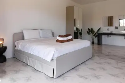 a bedroom with a large white bed with a sink at Modern Villa 4-BR, Breeze - 10 min walk to NaiYang beach in Nai Yang Beach