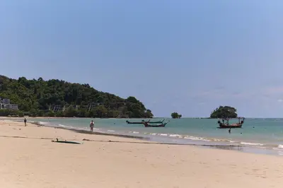a beach with two boats in the water at Modern Villa 4-BR, Breeze - 10 min walk to NaiYang beach in Nai Yang Beach