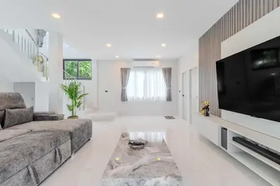 a living room with a couch and a flat screen tv at 4BR Big Pool 2 Villas Same Land Near Nai Harn V258 in Rawai Beach