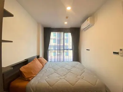 a bedroom with a bed in front of a window at The Central Escape Phuket in Ban Rangeng