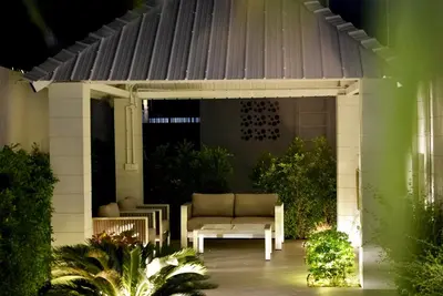 a white pergola with a couch on a porch at Villa Sofia in Ban Phak Chit