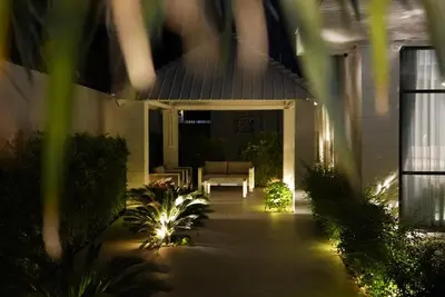 a porch of a house at night with a couch at Villa Sofia in Ban Phak Chit
