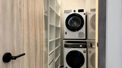 two washers and a dryer in a closet at Villa Sofia in Ban Phak Chit