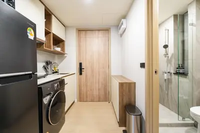 a kitchen with a washer and dryer next to a door at Boat Avenue Modern Loft in Ban Thalat Choeng Thale
