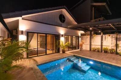 a villa with a swimming pool at night at Luxury 3 bed villa with private pool, Rawai Phuket in Rawai Beach