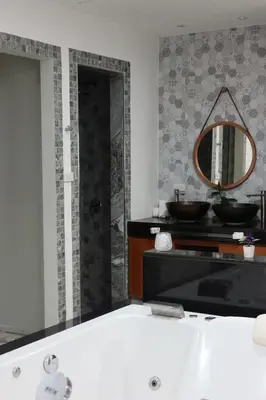 a bathroom with a bath tub and a mirror at Baan Chang Sanctuary in Laguna Phuket