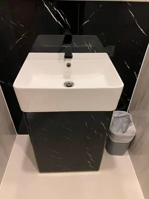 a white sink in a bathroom with a black wall at Utopia Karon Sea View Apartments in Karon Beach