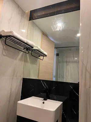 a bathroom with a white sink and a mirror at Utopia Karon Sea View Apartments in Karon Beach